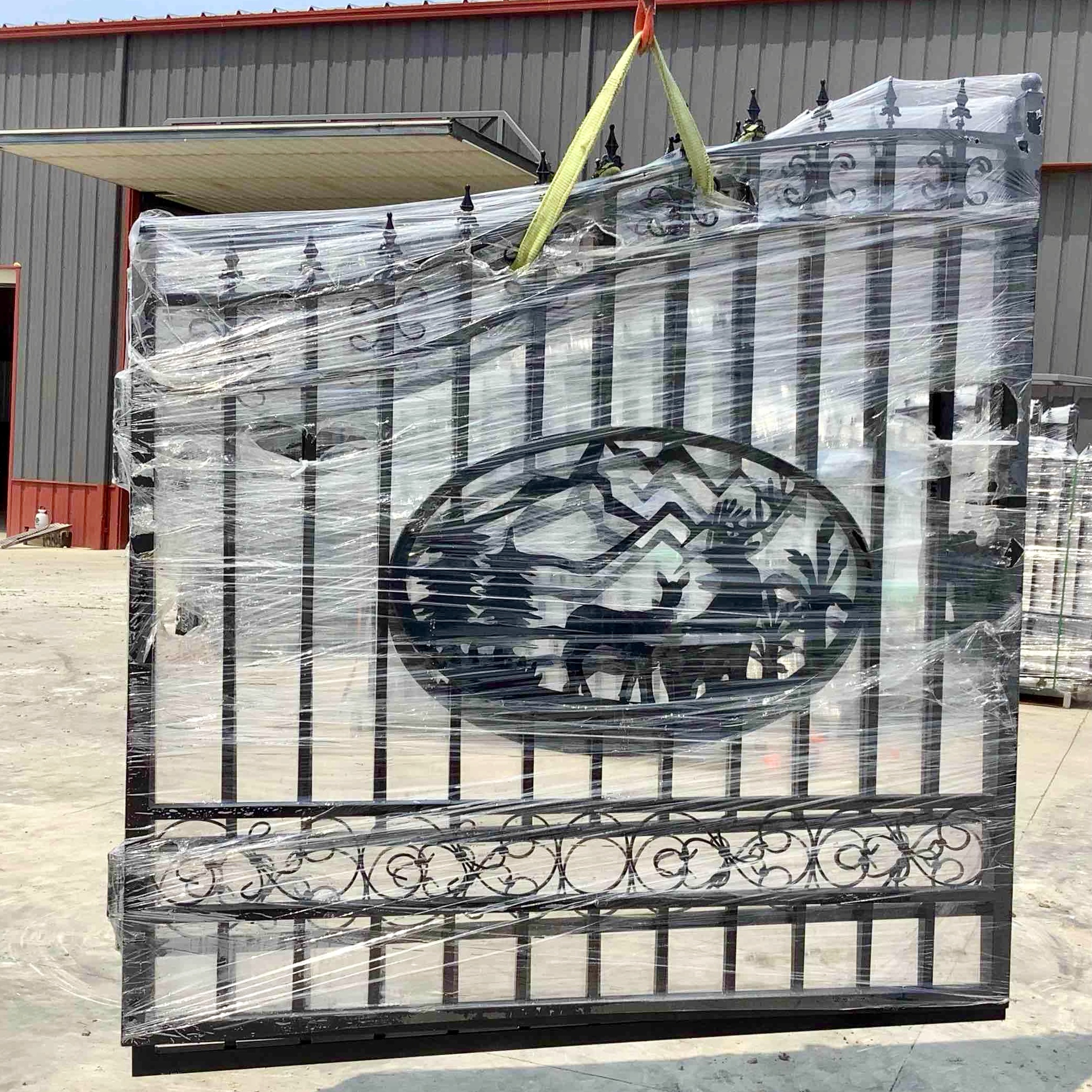 Fourteen foot wide pair of wrought iron style gates with a deer nature scene in the. center of each gate