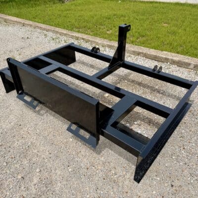 Black steel foundation frame for portable building shed with leveling skids on gravel driveway