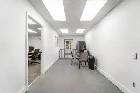 Interior flex area with a table, chairs, refrigerator and exterior door.