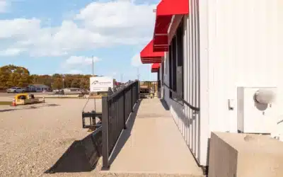 Concrete entry ramp with handrails along the front of the building.
