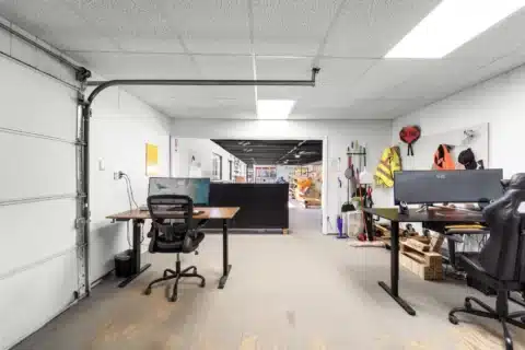 Reverse view of a work area with desks and an overhead garage door.