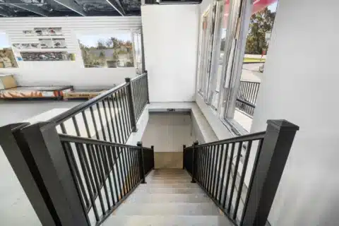Interior stairway connecting the upper showroom and lower level.