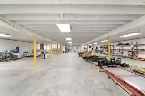 Long lower-level view with shelving and open concrete floor.