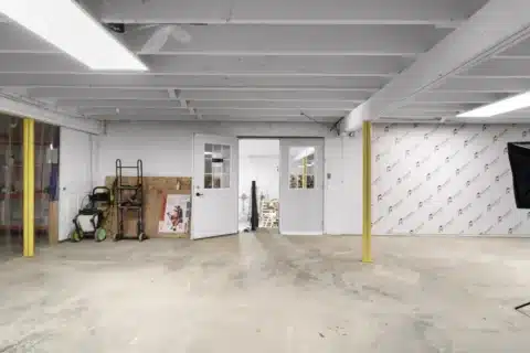 Open lower-level work area with interior doors and a partition wall.