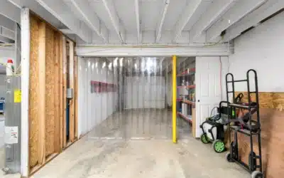 Lower-level storage area with a clear strip partition and utility equipment.