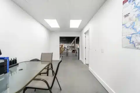 Interior flex area with table, chairs and an opening to the showroom.