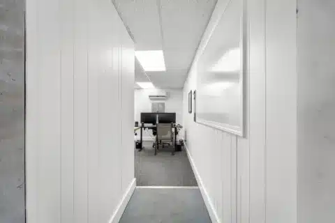 Short interior hallway leading to a furnished office.