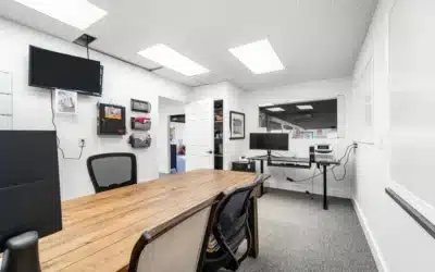 Office with workstations and interior windows.