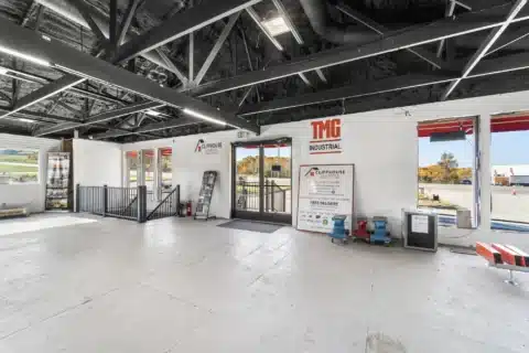 Angled interior view of the glass front entrance and nearby stair railing.