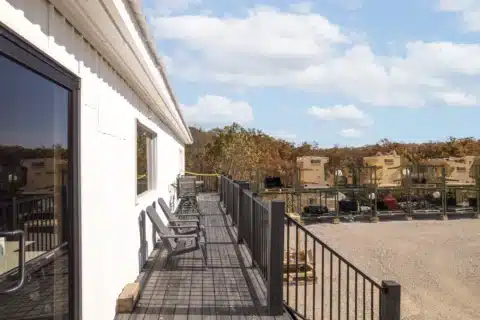 Raised exterior walkway with railings along the side of the building.