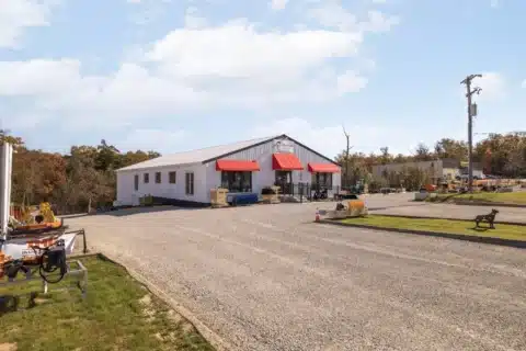 Wide front view of the commercial building and gravel parking area.