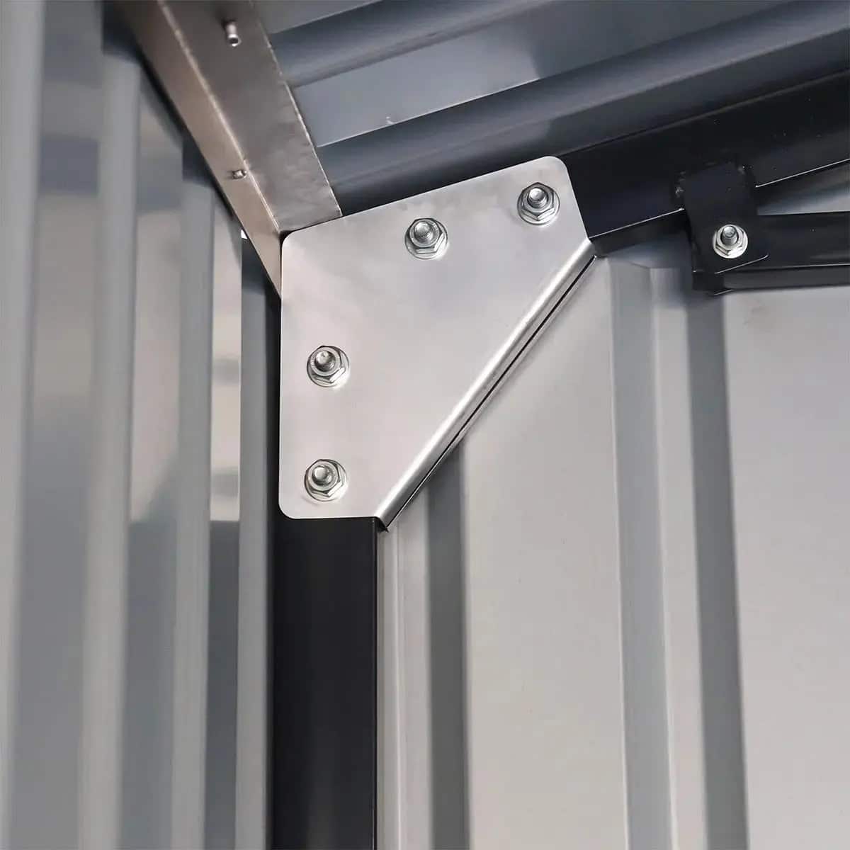 Close-up of a silver diagonal metal bracket bolted to a gray industrial door frame.