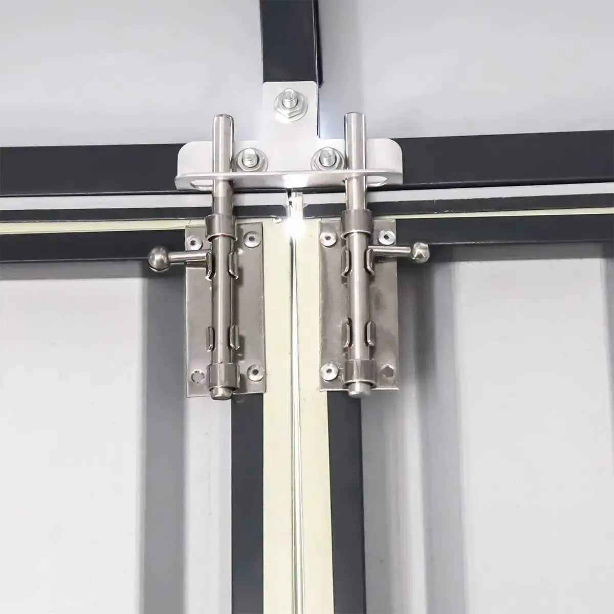 Close-up of a metal sliding door hardware assembly with two vertical hinges and a central spindle on a track.