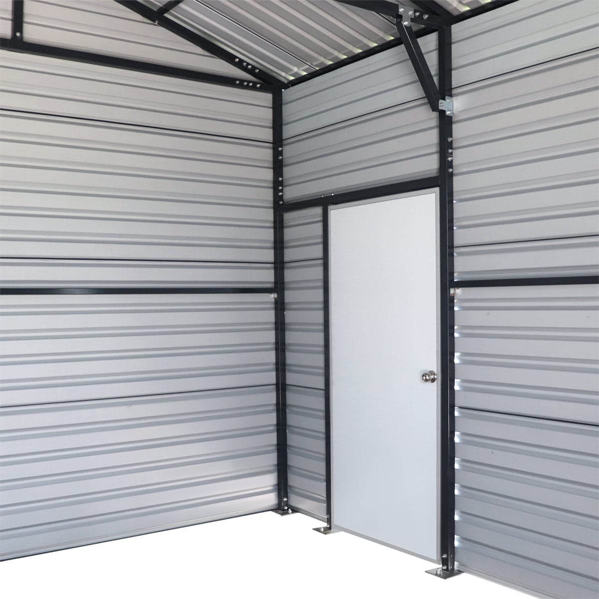 Interior of a metal storage unit with corrugated gray walls and a white entry door with knob in the corner.